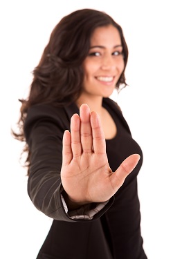 Smiling woman with her hand held up in a stop gesture