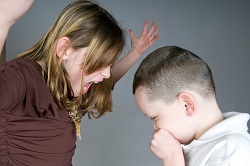 Woman yelling at sniffling boy