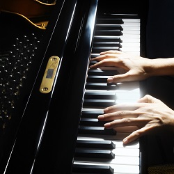 hands playing a piano keyboard