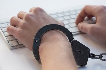 typing on computer keyboard while wearing handcuffs