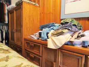clothes piled up on dresser and armoire