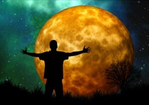 Man looking at moon with arms outstretched